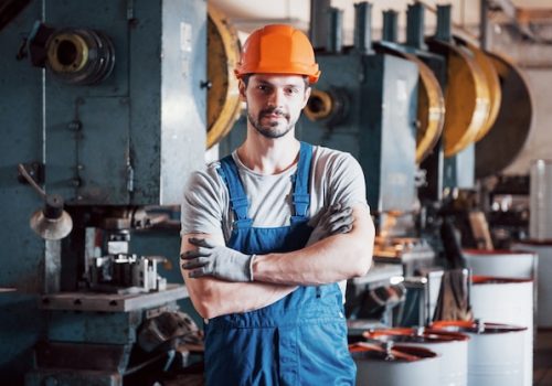 portrait-young-worker-hard-hat-large-metalworking-plant_146671-19573